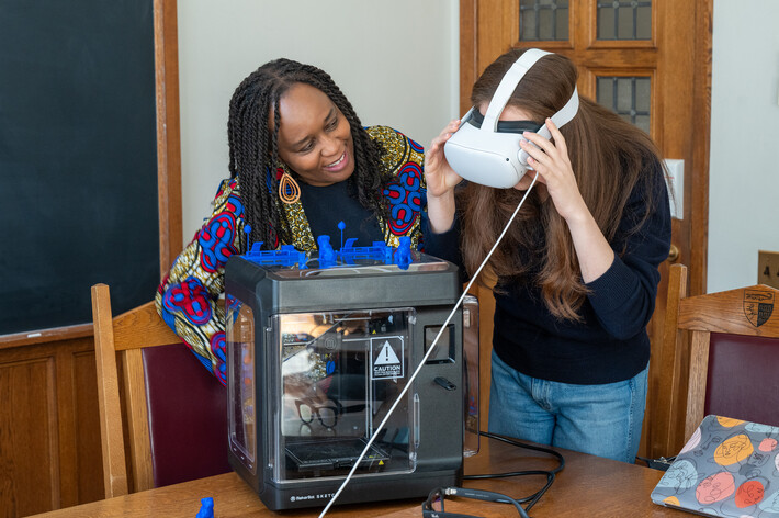 Femi Cadmus works with a student wearing a virtual reality headset