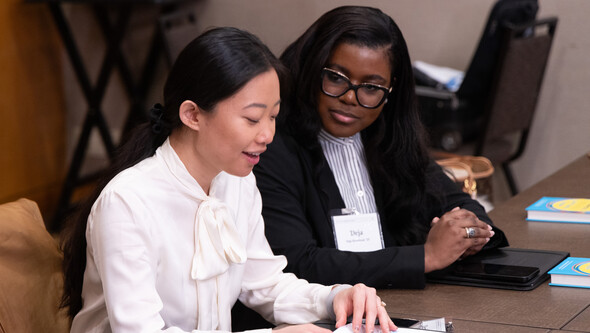 two students talking at a table