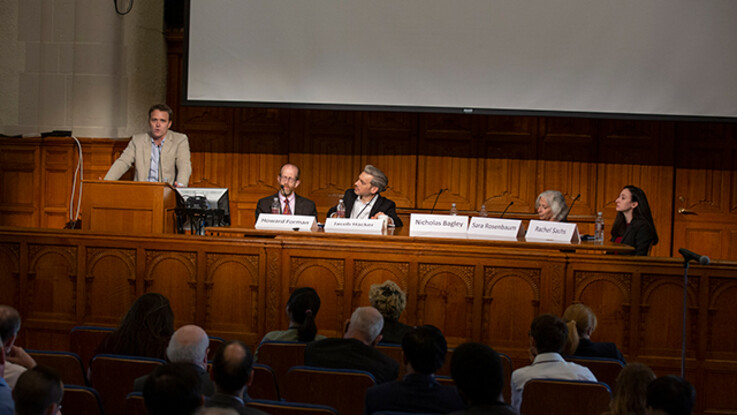 Panel 4 seated at desk at front of lecture hall
