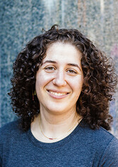 Josephine Wolff smiles at the camera in front of a speckled marble background.