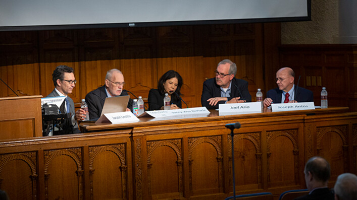 Panel 1 members seated at desk in front of lecture hall