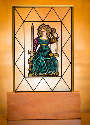stained glass medallion resting in an oak base with a brass plaque